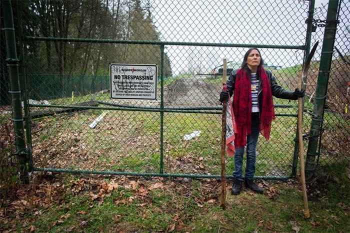  Kat Roivas, who is opposed to the expansion of the Kinder Morgan Trans Mountain pipeline, stands at an access gate at the company's property near an area where work is taking place, in Burnaby, B.C., on Monday April 9, 2018. THE CANADIAN PRESS/Darryl Dyck