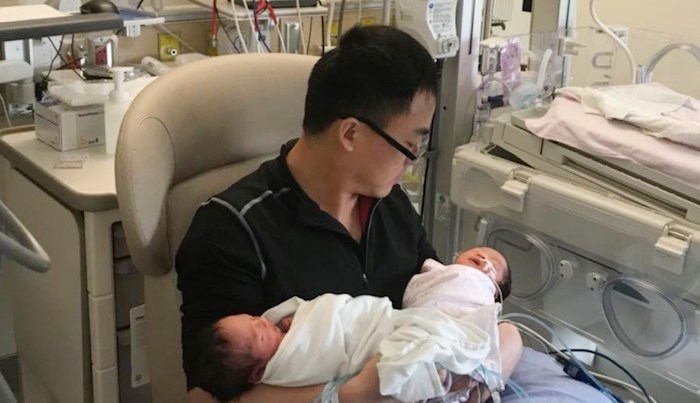  Victor Yu holds his twin daughters after his wife died in childbirth. Photo submitted
