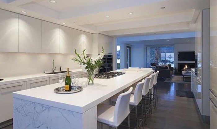 The sleek , all-white kitchen of this West Vancouver house opens up to a welcoming family room, making this home not just spectacular but also livable. Listing agent: Malcolm Hasman