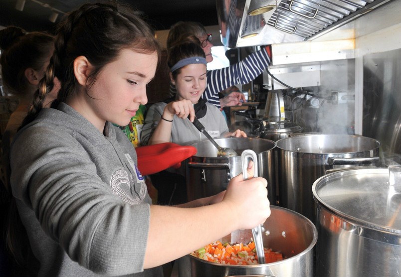  MARIO BARTEL/THE TRI-CITY NEWS Ana Iancu and Chelsea Wilson, students from Pitt River middle school, carmelize the vegetables for the soup they're making at Gallery Bistro that will be donated to a women's shelter in the Tri-Cities.