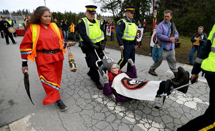  Burnaby RCMP carry away a protester from the Kinder Morgan site. Photograph By Jennifer Gauthier