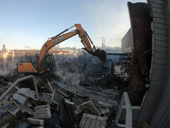  An excavator on scene picking apart what's left of the building. Photo VF&R