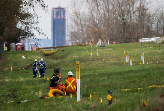  Two workers talk as flags mark an underground pipeline location as work continues at Kinder Morgan's facility in preparation for the expansion of the Trans Mountain Pipeline, in Burnaby, B.C., on April 9, 2018. Details are expected to be released today about British Columbia's court case that questions if the province has the power to regulate the flow of oil from the Trans Mountain pipeline expansion. Premier John Horgan has said a reference case will be filed in B.C.'s Court of Appeal by April 30, seeking to clarify the province's rights to protect its environment and economy from an oil spill. THE CANADIAN PRESS/Darryl Dyck
