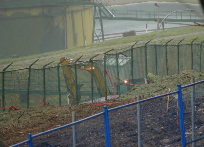  An excavator works in the rain next to an area of exposed earth at the northeastern section of the Trans Mountain terminal on Burnaby Mountain, April 13.   Photograph By John Preissl, Contributed