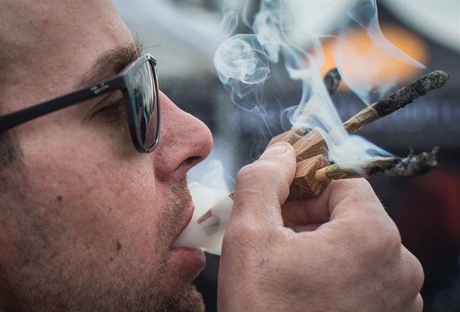  Brandon Bartelds smokes three joints at once while attending the 4-20 annual marijuana celebration, in Vancouver, B.C., on Friday April 20, 2018. British Columbia may have unveiled its plan for regulating recreational marijuana, but the enforcement and testing for drug-impaired driving remains hazy. THE CANADIAN PRESS/Darryl Dyck