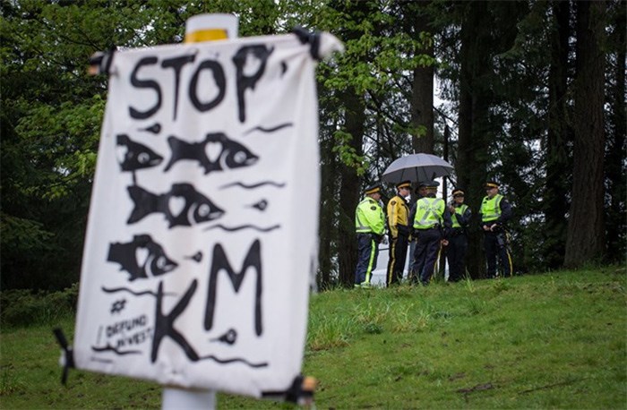  RCMP officers gather nearby as protesters opposed to the Kinder Morgan Trans Mountain Pipeline expansion defy a court order and block a gate at the company's facility, in Burnaby, B.C., on Saturday April 28, 2018. THE CANADIAN PRESS/Darryl Dyck