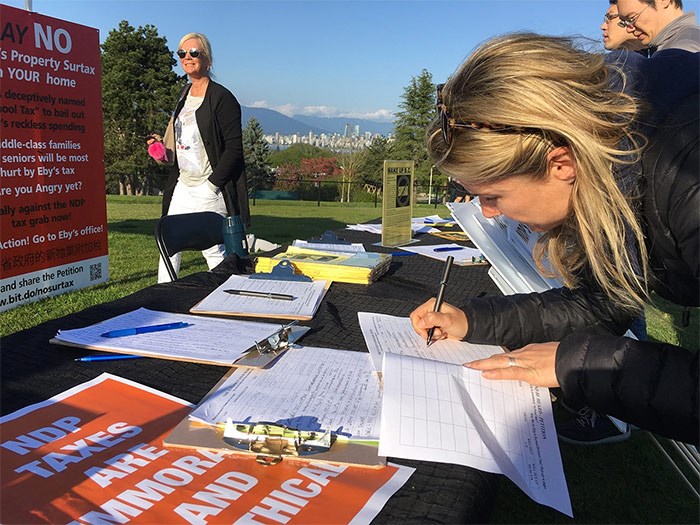  Before the May 1 rally, there were 9,600 signatures on a petition against the B.C. government's surtax on properties worth more than $3 million. Several people added their names at the Trimble Park event. - Martha Perkins