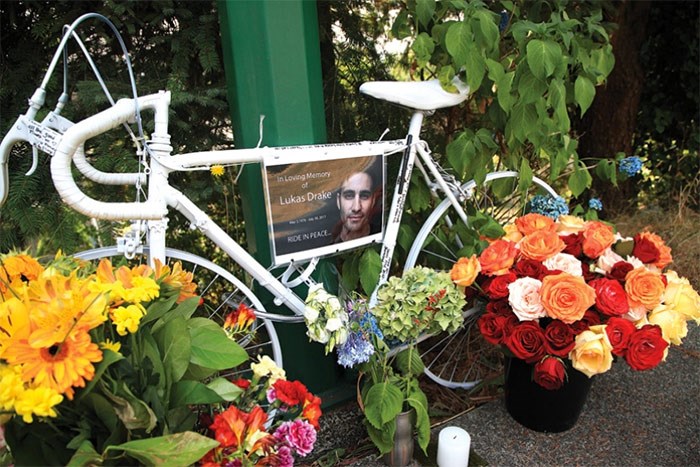  Floral tributes surround a “ghost bike” memorial on Shavington Street for a cyclist killed in a nearby collision, in this image taken days after the July 2017 crash. file photo Kevin Hill, North Shore News