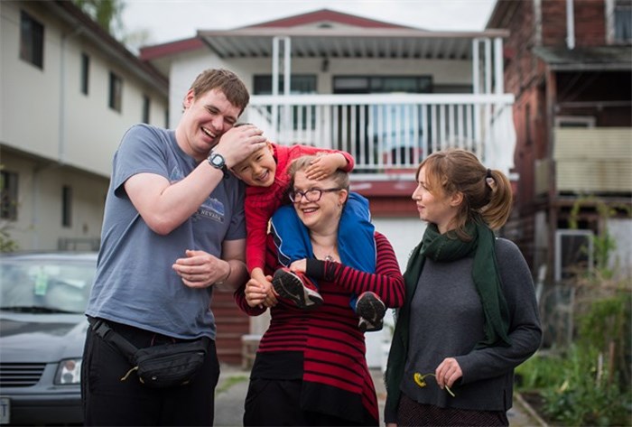  Patrick Caldicott, left, shares a laugh with Laelo Vervecken-Wong, 4, as he's held by his mom Anika Vervecken, centre, while posing for a photograph along with Megan Brydie, right, who all live together in a house, in Vancouver, B.C., on Monday April 30, 2018. In a city known for soaring real estate prices, low vacancies and a frostiness to strangers, some Vancouver residents are finding innovative ways of blending their housing and social needs. It's called collective housing, where several people live together not only to share a space, but to create a community where resources and work are shared. THE CANADIAN PRESS/Darryl Dyck