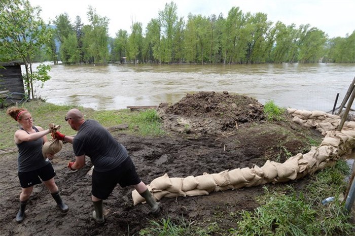  People place sandbags along the banks of the Kettle River in Grand Forks, B.C., on Thursday, May 17, 2018. THE CANADIAN PRESS/Jonathan Hayward