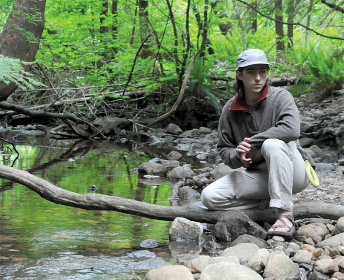  Jamie Martz, volunteer with North Shore Streamkeepers, crouches at the edge of Hastings Creek, where construction debris has damaged a fish habitat. photo Mike Wakefield, North Shore News