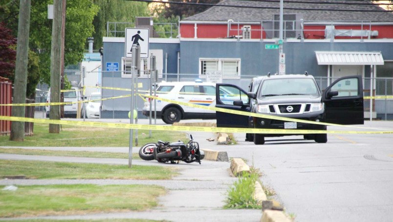  A motorcycle lies behind police tape at the scene of Sunday morning's shooting on Saunders Road near No. 4 Road. Shane MacKichan photo
