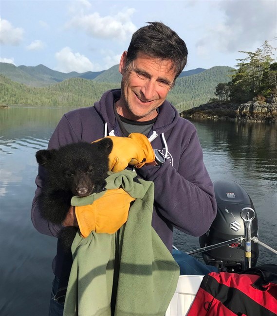  John Forde, the co-owner of the Whale Centre in Tofino, B.C., holds an orphaned black bear cub near Tofino in a handout photo. THE CANADIAN PRESS/HO-Tofino Whale Centre-Jennifer Steven