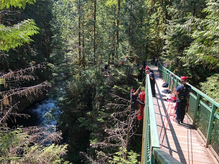  District of North Vancouver fire crews prepare to lift two stranded boaters to safety on the Pipeline Trail bridge over the Capilano River. photo supplied