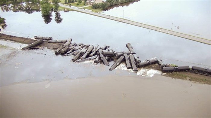  In this aerial drone image taken from video and provided by the Sioux County Sheriff's Office, tanker cars carrying crude oil are shown derailed about a mile south of Doon, Iowa, Friday, June 22, 2018. About 31 cars derailed after the tracks reportedly collapsed due to saturation from flood waters from adjacent Little Rock River. (Sioux County Sheriff's Office via AP)