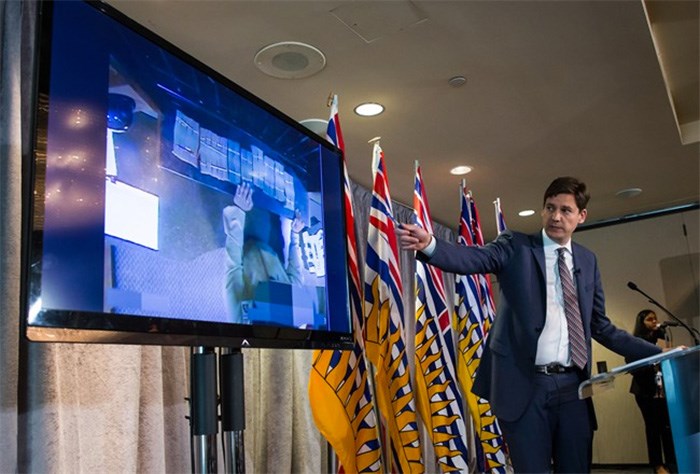  B.C. Attorney General David Eby gestures while showing a video of bundles of cash brought to a casino by a person, after releasing an independent review of anti-money laundering practices during a news conference in Vancouver, on Wednesday June 27, 2018. THE CANADIAN PRESS/Darryl Dyck