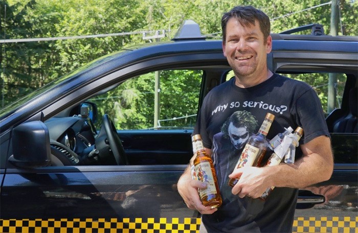  Bowen Island’s only taxi owner, Mike Shannon, holds some of the bottles of rum — including the one that was stolen — that people gave him after reading of his travails on Facebook.