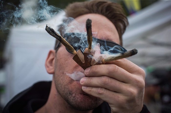  Brandon Bartelds smokes three joints at once while attending the 4-20 annual marijuana celebration, in Vancouver, B.C., on Friday April 20, 2018. One of British Columbia's busiest rescue teams is warning backcountry hikers not to get high on their hike. THE CANADIAN PRESS/Darryl Dyck