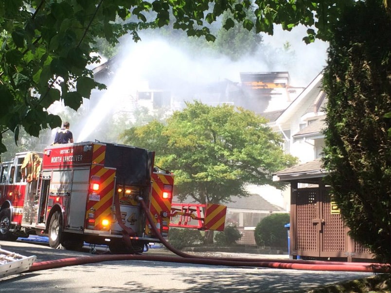  District of North Vancouver firefighters battle a blaze at Lions Manor Deep Cove, a seniors complex in Deep Cove Tuesday afternoon. Fire crews were still fighting the fire at press time. About 100 people had been evacuated to Parkgate Community Centre. photo Paul McGrath, North Shore News