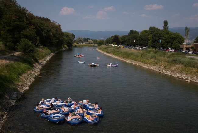  People float on a river channel that connects Okanagan and Skaha Lakes, in Penticton, B.C., on Monday August 6, 2018. THE CANADIAN PRESS/Darryl Dyck