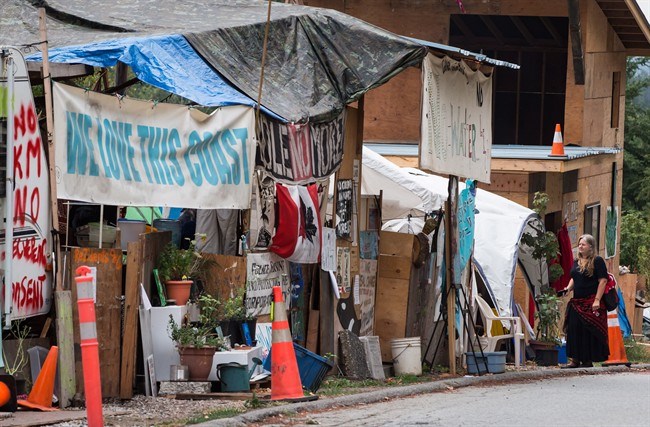  A woman stands at a protest camp outside a Kinder Morgan terminal, in Burnaby, B.C., on Sunday, August 12, 2018. On Friday, a B.C. Supreme Court judge granted the City of Burnaby an injunction forcing pipeline protesters to remove all structures, shelters and vehicles outside the terminal within 48 hours. THE CANADIAN PRESS/Darryl Dyck