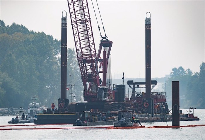  Spill response workers adjust a boom after a tugboat capsized and sank on the Fraser River between Vancouver and Richmond, B.C., on Tuesday August 14, 2018. Canadian Coast Guard spokesman Dan Bate said it's unknown what caused the George H. Ledcor tug to capsize early Tuesday near Vancouver International Airport. Four people aboard the vessel were all rescued. THE CANADIAN PRESS/Darryl Dyck