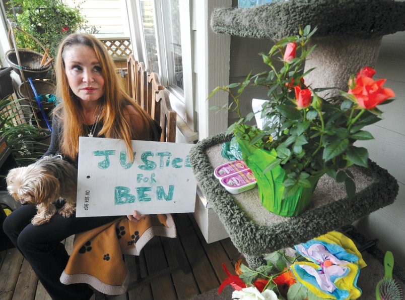  Deborah Stockwell holds her dog, Sacha, while looking at a makeshift shrine for her cat, Ben. Neighbours have been dropping off tributes after Ben was found dead with a sandwich bag on its head in a ravine near Stockwell’s home. The owner believes her pet was the victim of foul play. photo Mike Wakefield, North Shore News