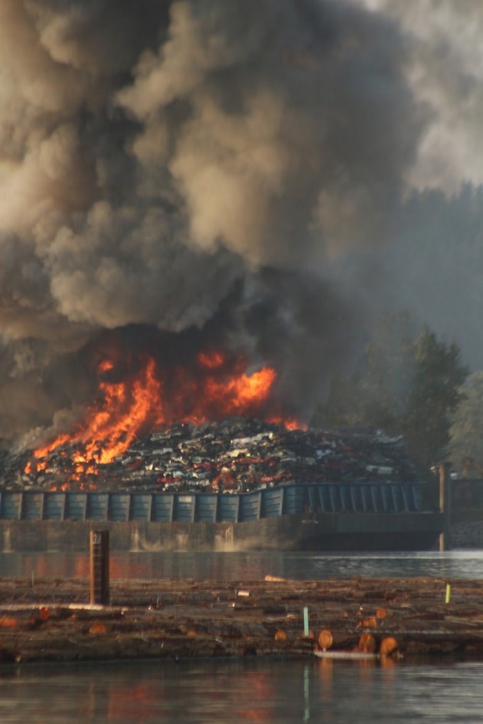  Plumes of thick black smoke filled the skies on Friday as a barge carrying scrap metal burned on the shores of the Fraser River. Some community members have expressed concern about the fire's impact on fish and the Fraser River.