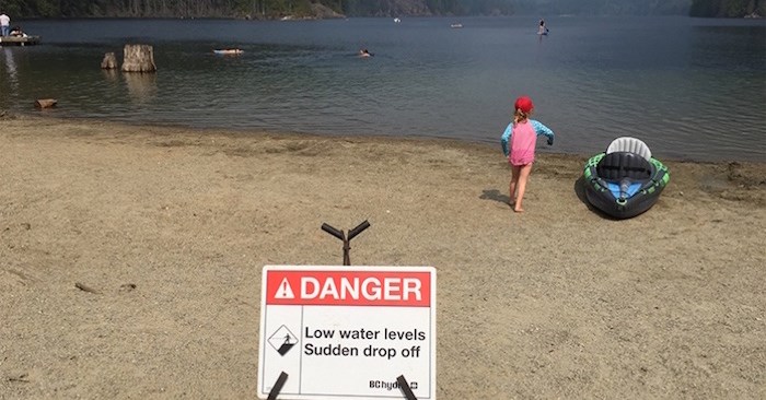  A warning sign at Buntzen Lake. Beach-goers need to take extra precautions because the lake bottom drops off quite steeply near the shore when the water is low. This week a man drowned at the popular lake.