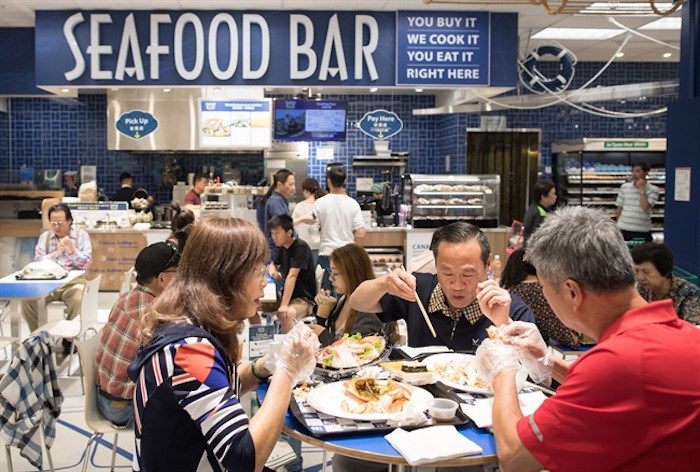  People eat at a seafood bar at T&T Supermarket's newest location, in Richmond, B.C., on Tuesday August 21, 2018. Shoppers can purchase fresh seafood in the store and have it steamed or baked to be eaten on site. Grocery stores increasingly blur the line between supermarkets and restaurants with large chains adding take-out meals to their shelves, hot food counters where chefs make dishes to order and even full-service restaurants. Dubbed grocerants, these combination spaces serve a time-strapped population that values convenience. THE CANADIAN PRESS/Darryl Dyck