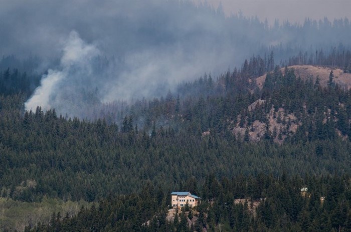  The Shovel Lake wildfire burns on a mountain behind a home near Fort Fraser, B.C., on Thursday August 23, 2018. Government statistics indicate this year's wildfire season is the second worst in British Columbia's history, burning 945 square kilometres of land. THE CANADIAN PRESS/Darryl Dyck