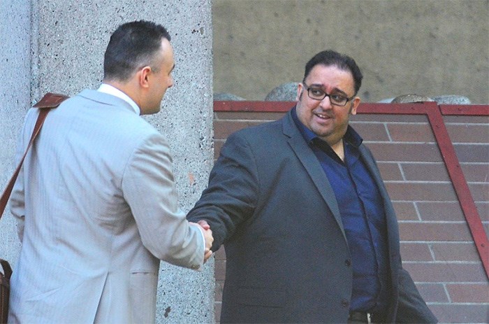  Former Burnaby realtor Kuljinder Singh (Kelly) Bhatti shakes hands with his lawyer, Mark Berry, after leaving B.C. Provincial Court in Vancouver Monday. Bhatti was handed a one-year suspended sentence after being caught in a Surrey Creep Catchers sting on April 3, 2017.