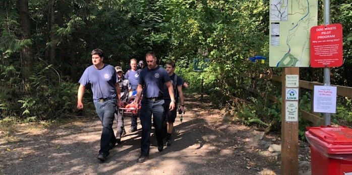  District of North Vancouver firefighters and ambulance paramedics carry a man off the Grouse Grind after saving him after he had a heart attack on the trail Sunday. Photo supplied.