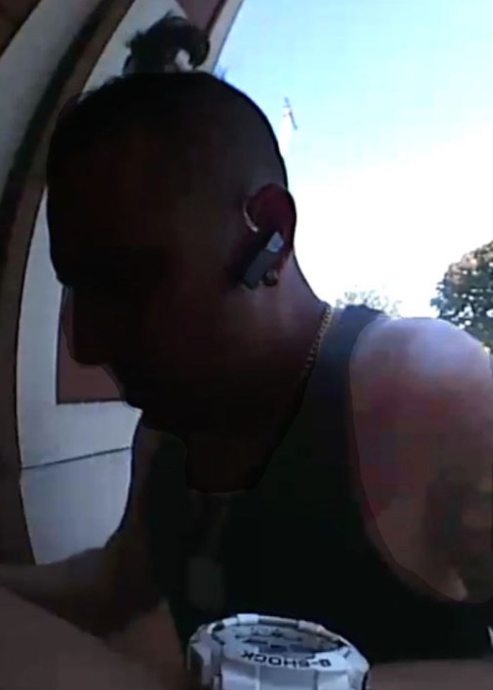  The thief's face is difficult to see in the video captured by a surveillance camera, but he is clearly seen taking mail from the mailbox. (Screenshot/submitted)