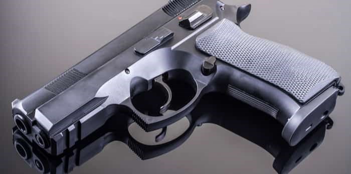  Photo: hand gun on glass table / shutterstock