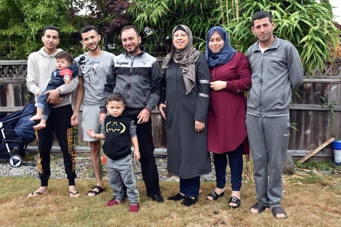  The Shebat family stand together in Burnaby. Left to right: Fares (holding Zain), Mohammed, Mamoun (with Amir), Khloud, Fedaa and Taj. (Photo by Kelvin Gawley)