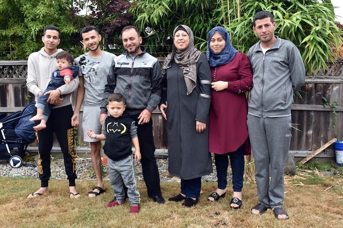  The Shebat family stand together in Burnaby. Left to right: Fares (holding Zain), Mohammed, Mamoun (with Amir), Khloud, Fedaa and Taj. (Photo by Kelvin Gawley)