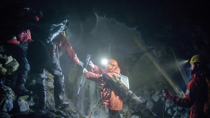  A member of North Shore Rescue helps one of the hikers down the mountain early Saturday morning. The team was called out after two women became lost near Coliseum Peak in the rain and dark on Friday night (Photo courtesy Ian Christie)