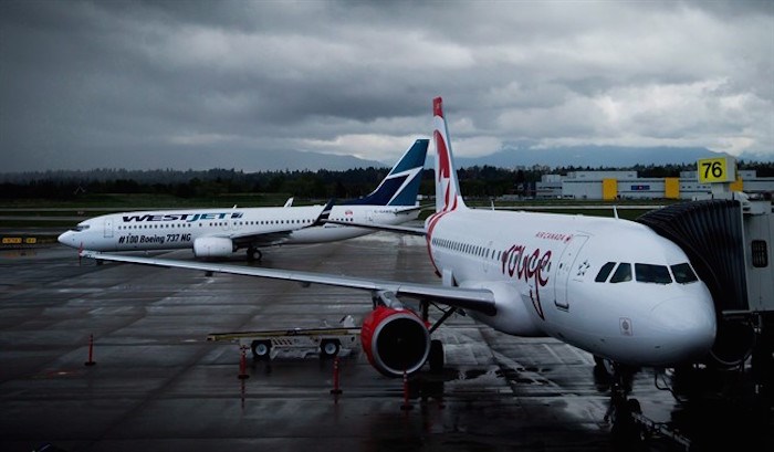  A Westjet Boeing 737-800, left, taxis past an Air Canada Rouge Airbus A319 at Vancouver International Airport in Richmond, B.C., on Monday, April 28, 2014. The federal Competition Tribunal has set a date for hearings between the Vancouver Airport Authority and the Competition Bureau, which has accused the airport operator of imposing restrictions it says decrease competition among in-flight catering companies. THE CANADIAN PRESS/Darryl Dyck