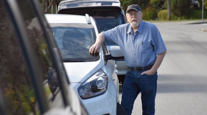  Eric Anderson stands by his car on Brentlawn Drive, where a potential new parking rule could keep him from parking. Photograph By Kelvin Gawley