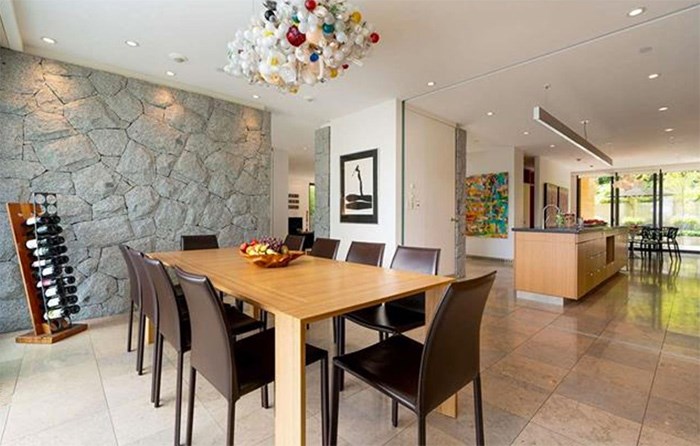  The dining room has one of a number of outdoor-to-indoor feature rock walls, and is open to the kitchen. Listing agent: Faith Wilson