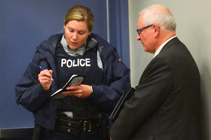  Incumbent Burnaby Citizens Association trustee candidate Larry Hayes is interviewed by police after an altercation at an all-candidates meeting at Byrne Creek Community School Wednesday evening. - Cornelia Naylor