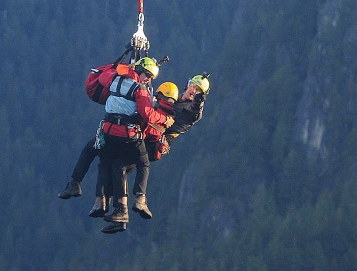  Members of North Shore Rescue prepare to touch down at the bottom of a helicopter long line early Tuesday morning. photo Mike Wakefield, North Shore News