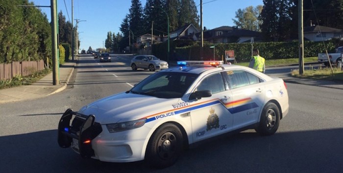  A police officer stops traffic on Canada Way before Usher Street, where a pedestrian was struck Saturday. The 84-year-old man has since died. Photo by Cornelia Naylor