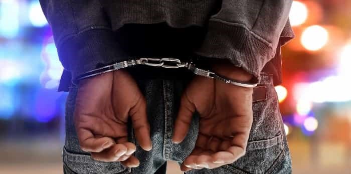  Photo: handcuffs and police lights / shutterstock