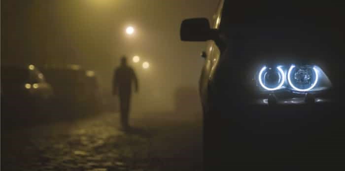  Photo: car headlight with a walking man on a fog background / Shutterstock