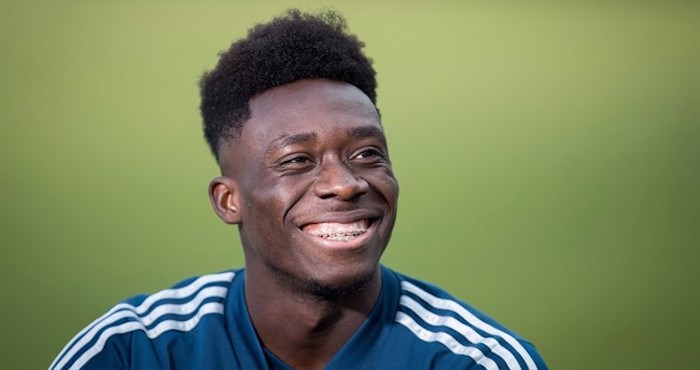 Vancouver Whitecaps midfielder Alphonso Davies laughs while talking to a teammate as he waits to begin an interview after MLS soccer practice in Vancouver, on Wednesday October 24, 2018. THE CANADIAN PRESS/Darryl Dyck