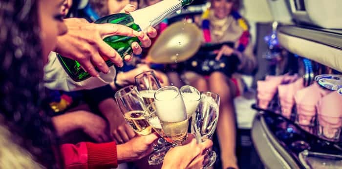  Photo: Happy girls having fun in limo, drinking champagne / Shutterstock