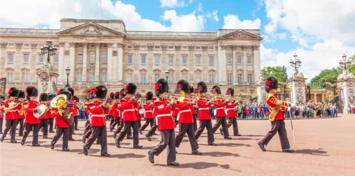  LONDON, UNITED KINGDOM - JULY 11, 2012: The band of the Coldstream Guards marches in front of Buckingham Palace during the Changing of the Guard ceremony. / Shutterstock