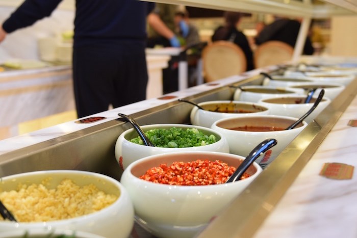  Customers choose their own sauces for their meals at a topping bar. Photo: Megan Devlin